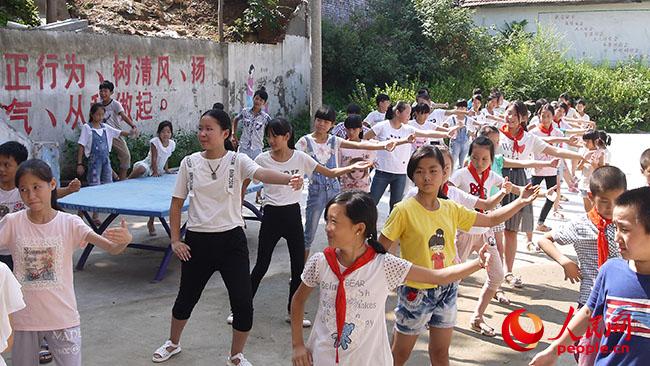 河南科技大學“一帶一路”義務支教與精準扶貧調研實踐團到河南宜陽縣香鹿山鎮磚古窯村開展義務支教和扶貧調研，圖為志愿者教孩子們太極拳。（團隊提供）